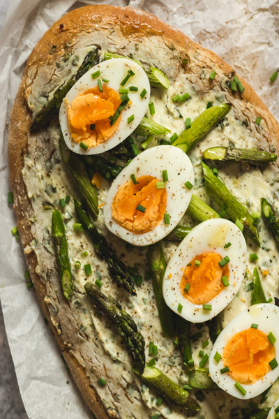 halved hard boiled eggs on toast with asparagus pieces